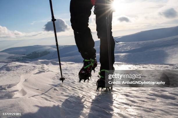 niedriger personenanteil, der auf einem schneefeld steht. - steigeisen stock-fotos und bilder