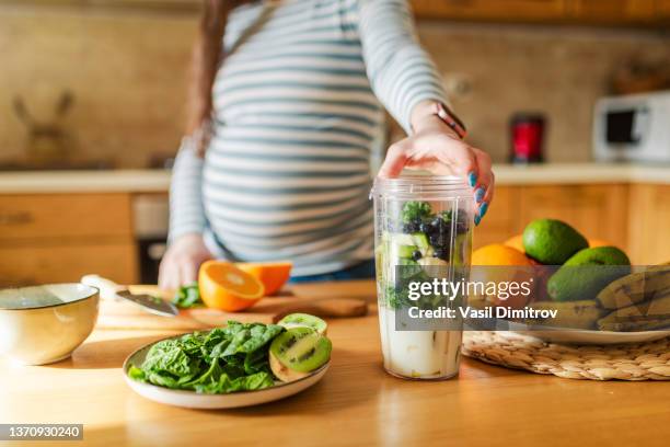 pregnant woman making healthy smoothie - smoothie and woman stockfoto's en -beelden