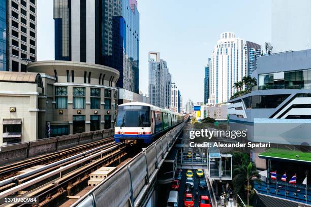 bangkok cityscape with overground railroad track and a moving train, thailand - bangkok city stock pictures, royalty-free photos & images