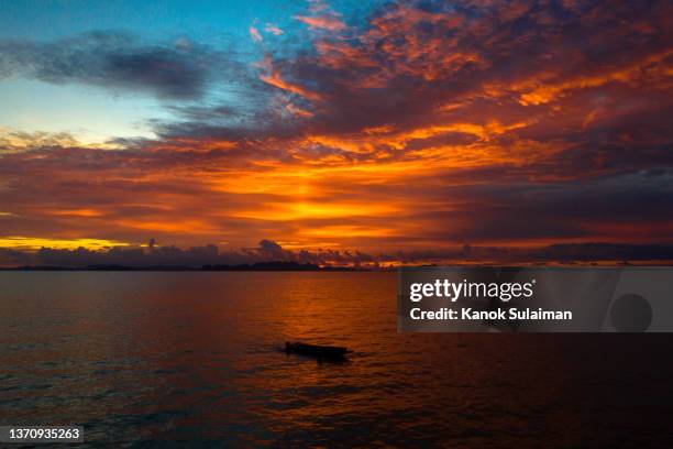 red sunset sky over the sea - hot summer nights film stock-fotos und bilder