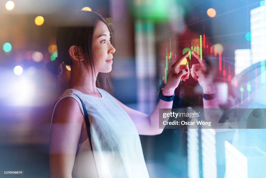 Young woman touching screen on futuristic digital display.