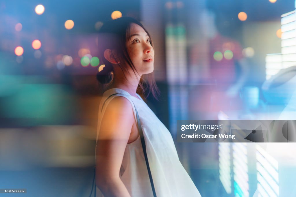 Young woman looking at futuristic digital display.