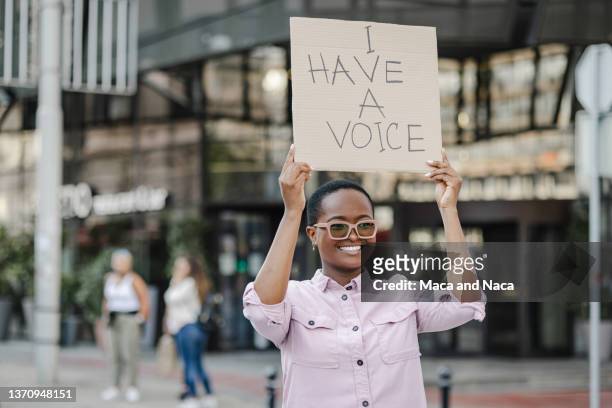 young african-american woman protesting on the street against racism - racial justice concept stock pictures, royalty-free photos & images