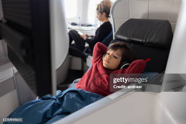 niño viajando en avión en clase ejecutiva y viendo una película - upper class fotografías e imágenes de stock