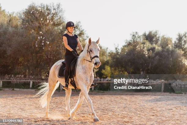 blonde frau auf ihrem pferd im schönen gegenlicht in einem rustikalen stall im freien auf mallorca - pferd natur stock-fotos und bilder