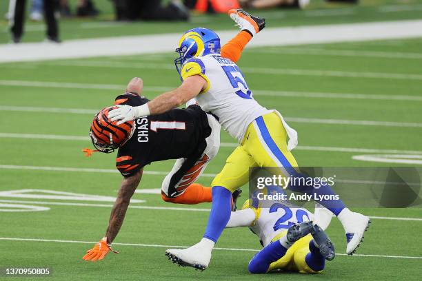 Ja'Marr Chase of the Cincinnati Bengals falls as Troy Reeder and Eric Weddle of the Los Angeles Rams defend during Super Bowl LVI at SoFi Stadium on...