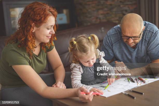 mother, father and baby girl blonde in home interior (coloring) - 2 year old blonde girl father stock pictures, royalty-free photos & images