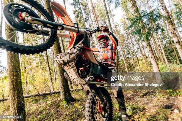 männliche porträt von motocross enduro-fahrer im freien. sportkonzept für den motorsport auf der sportbahn. profi-biker mit helm und stunt-motorrad. mann mit schützender sportbekleidung - amateur stock-fotos und bilder