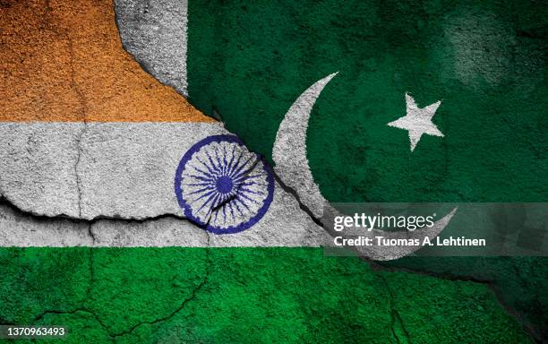full frame photo of weathered flags of india and pakistan painted on a cracked wall. - pakistani flag stock pictures, royalty-free photos & images