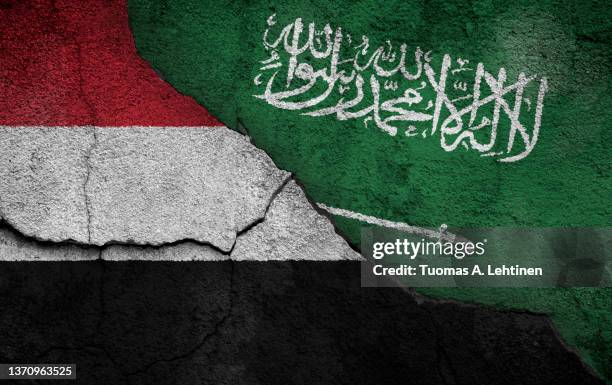 full frame photo of weathered flags of yemen and saudi arabia painted on a cracked wall. - saudi arabia flag stock pictures, royalty-free photos & images