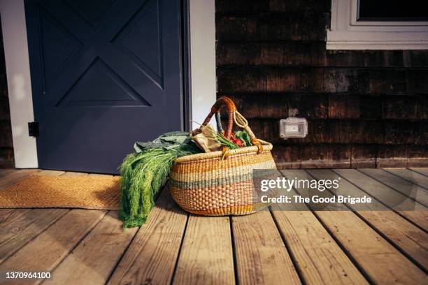 basket of fresh picked vegetables on front porch - porch stock-fotos und bilder