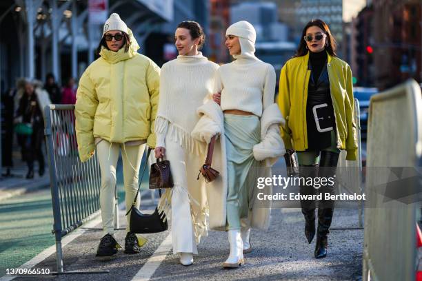 Guest wears a beige with a brown embroidered 6 pattern ribbed beanie, black sunglasses, a yellow high neck oversized puffer jacket, pale yellow slit...