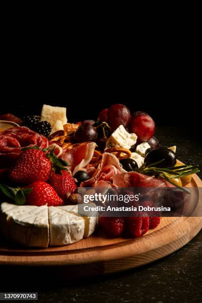 assortment of charcuterie and cheese on wooden board on concrete table. top view. - charcuterie board 個照片及圖片檔