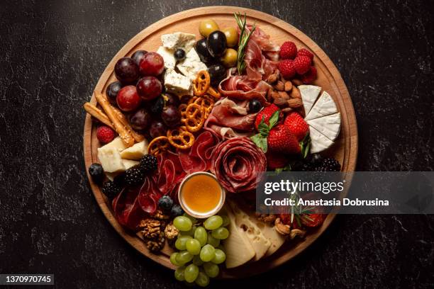 sortiment an wurstwaren und käse auf holzbrett auf betontisch. draufsicht. - charcuterie stock-fotos und bilder