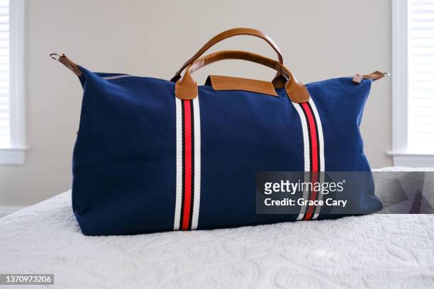 travel bag on bed - duffel tas stockfoto's en -beelden