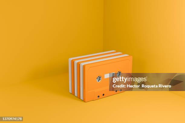 many retro orange and white  cassette tape with yellow background, 3d render - audio cassettes photos et images de collection