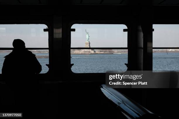 Man looks out at The Statue of Liberty in New York Harbor from the Staten Island Ferry on February 16, 2022 in New York City. A newly released...