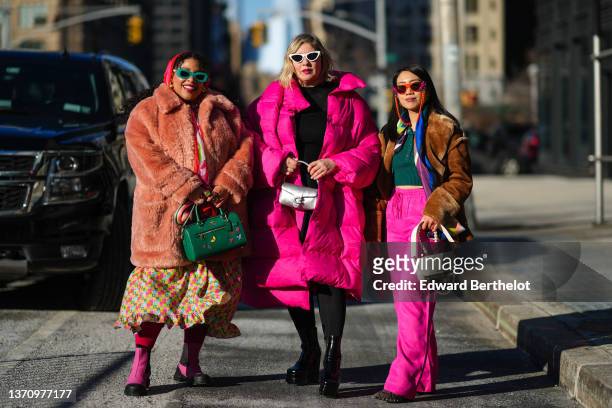 Greivy Lou wearing dark green sunglasses, a red / pink / green flower print pattern oversized silk scarf, a pale orange fluffy oversized winter coat,...
