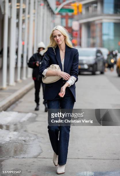 Guest is seen wearing navy blazer, creme white bag, dark denim jeans, ankle boots outside Collina Strada during New York Fashion Week on February 16,...