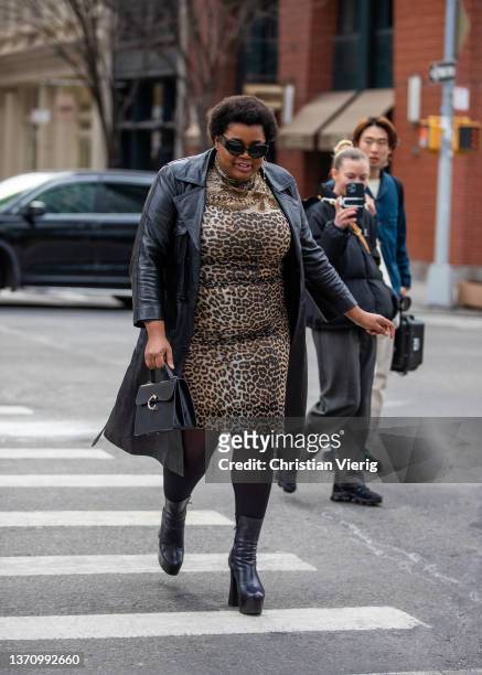 Gabriella Karefa Johnson seen wearing leopard animal print dress, black bag, black leather coat, tights, heeled ankle boots, sunglasses outside...