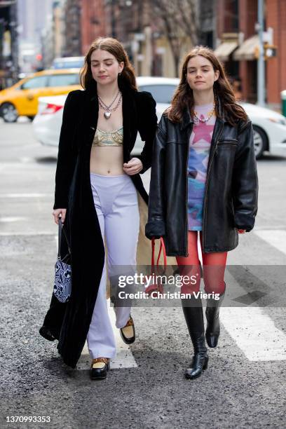 Sisters Reese Blutstein & Molly Blutstein wearing Prada bag, white pants, cropped top velvet coat, red tights, dress with print, black leather...