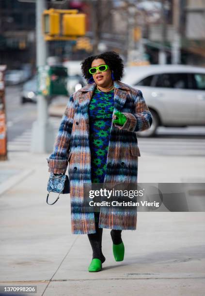 Greivy Lou is seen wearing green sunglasses, gloves, striped coat, navy dress with floral print, blue bag, green shoes outside Prabal Gurung during...