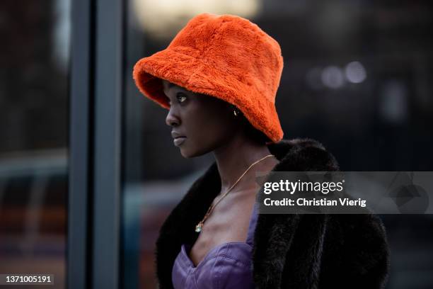Model is seen wearing orange bucket hat, purple cropped top, wild leather pants, brown coat outside Prabal Gurung during New York Fashion Week on...