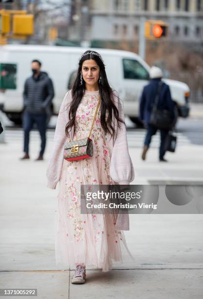 Guest is seen wearing hair clip, rose dress with floral print Gucci bag, long cardigan outside Prabal Gurung during New York Fashion Week on February...