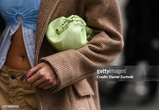 Guest is seen with a lime green Bottega Venetta bag outside the Collina Strada show during New York Fashion Week A/W 2022 on February 16, 2022 in New...