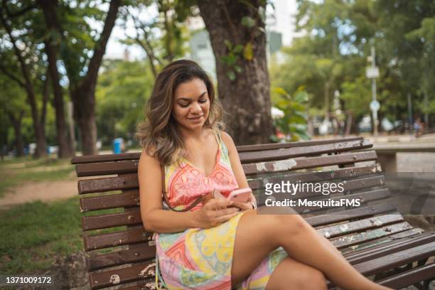 woman sitting on park bench - moving down to seated position stock pictures, royalty-free photos & images