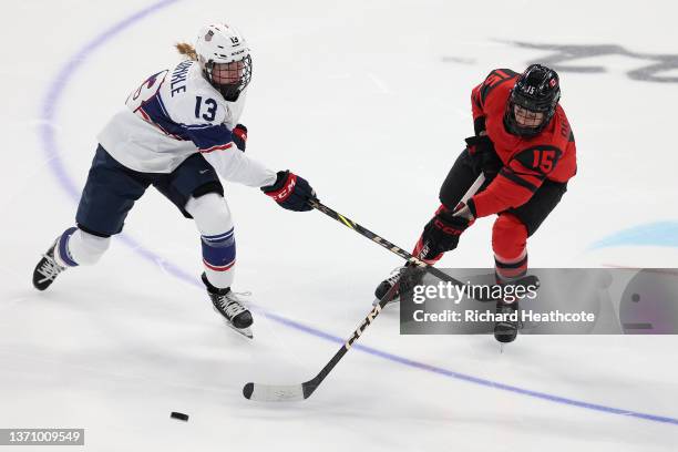 Grace Zumwinkle of Team United States slashes at the stick of Melodie Daoust of Team Canada in the first period during the Women's Ice Hockey Gold...