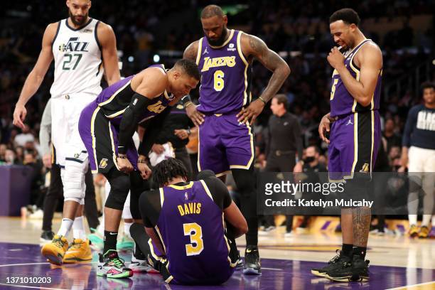 Russell Westbrook, LeBron James and Talen Horton-Tucker of the Los Angeles Lakers check up on teammate Anthony Davis after an injury during the...