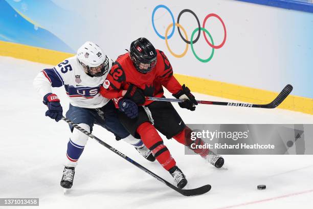 Alex Carpenter of Team United States and Claire Thompson of Team Canada vie for the puck in the first period during the Women's Ice Hockey Gold Medal...