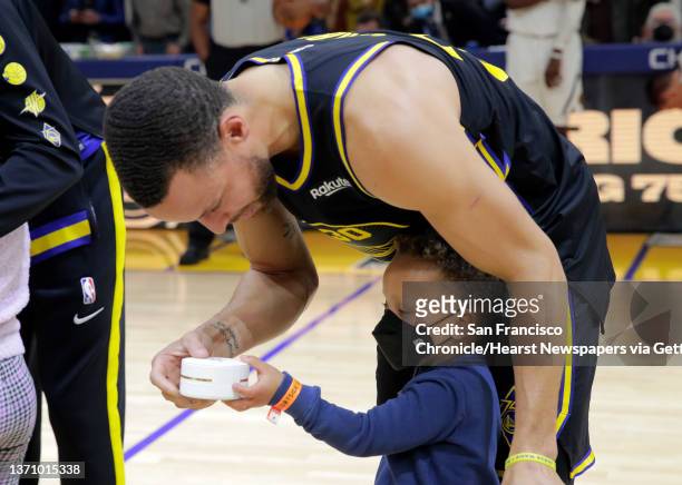 Stephen Curry , is presented with a commemorative All Star ring in a surprise by his son, Canon Curry, before the Golden State Warriors played the...