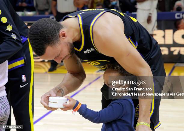 Stephen Curry , is presented with a commemorative All Star ring in a surprise by his son, Canon Curry, before the Golden State Warriors played the...