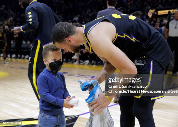 Stephen Curry , is presented with a commemorative ring in a surpriseby his son, Canon Curry, before the Golden State Warriors played the Denver...