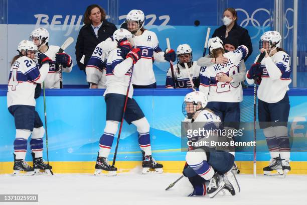 Amanda Kessel of Team United States hugs injured teammate Brianna Decker on the bench as teammates look on after their 3-2 loss to Team Canada the...