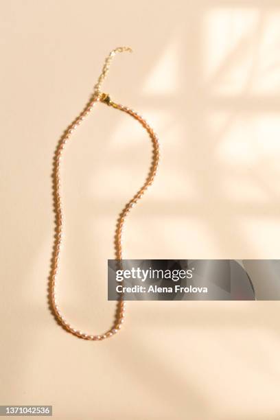 jewelry on beige background - gold chain necklace ストックフォトと画像