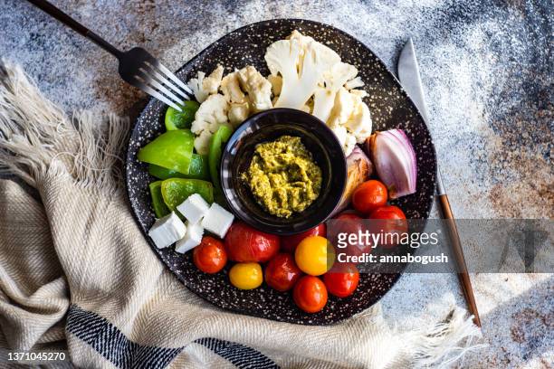 overhead view of fresh vegetable crudites and feta cheese with pesto dip - crudites stock pictures, royalty-free photos & images