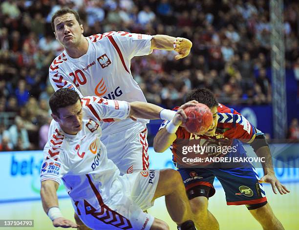 Serbia's Nenad Vuckovic vies with Poland's Bartlomiej Jaszka and Mariusz Jurkiewicz during their 10th EHF European 2012 Men's Handball Championship...