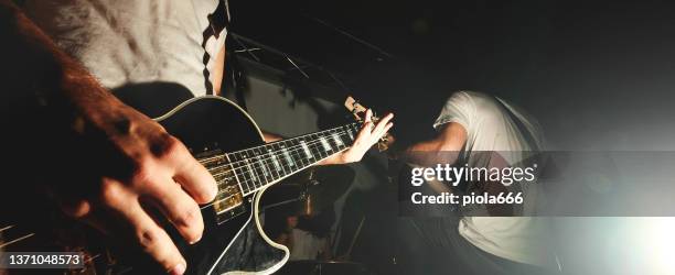 chitarrista hard rock che suona la chitarra in uno spettacolo dal vivo con luci sul palco - gruppo musicale foto e immagini stock