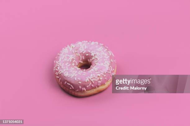 pink donut on pink background. - temptation stock-fotos und bilder