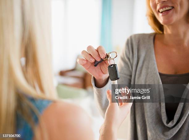 mother giving teenage daughter the car keys - conduite responsable photos et images de collection