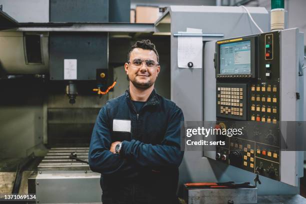 portrait d’un apprenti ingénieur souriant travaillant avec une machine cnc en usine - industrial portraits character photos et images de collection