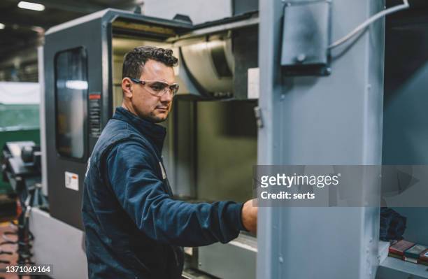 male apprentice engineer working with cnc machine in factory - cnc stock pictures, royalty-free photos & images