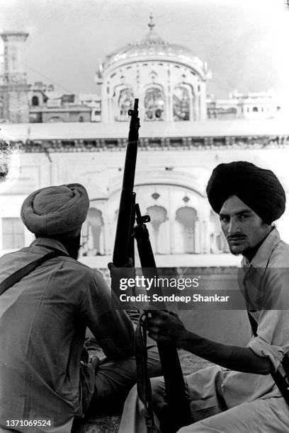 Two sikh militants sit with their rifles overlooking Gilden Temple in Amritsar June 02, 1984.
