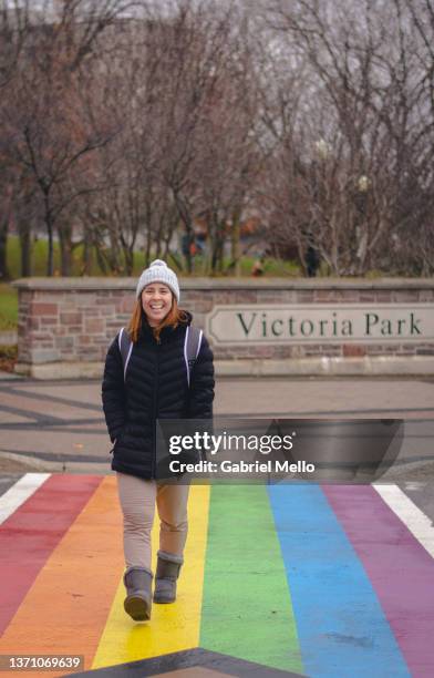 woman walking through a rainbow crosswalk kitchener canada - kitchener canada stock pictures, royalty-free photos & images