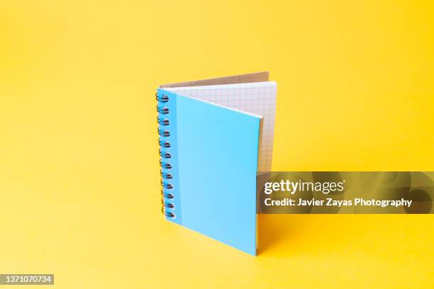 blue notepad on a yellow background - notebook paper desk stock pictures, royalty-free photos & images
