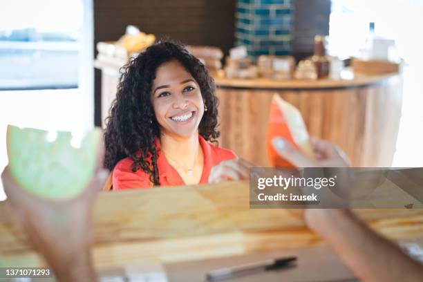 frau schaut verkäufer mit käsescheiben in der hand - cheesy salesman stock-fotos und bilder