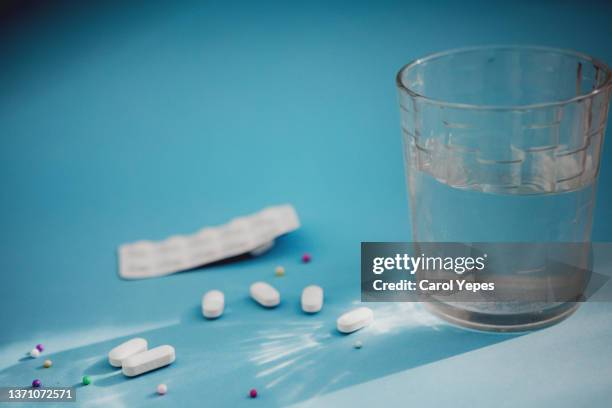 glass of  water and medical pills in blue surface with casting shadows - tablet alcohol stock pictures, royalty-free photos & images